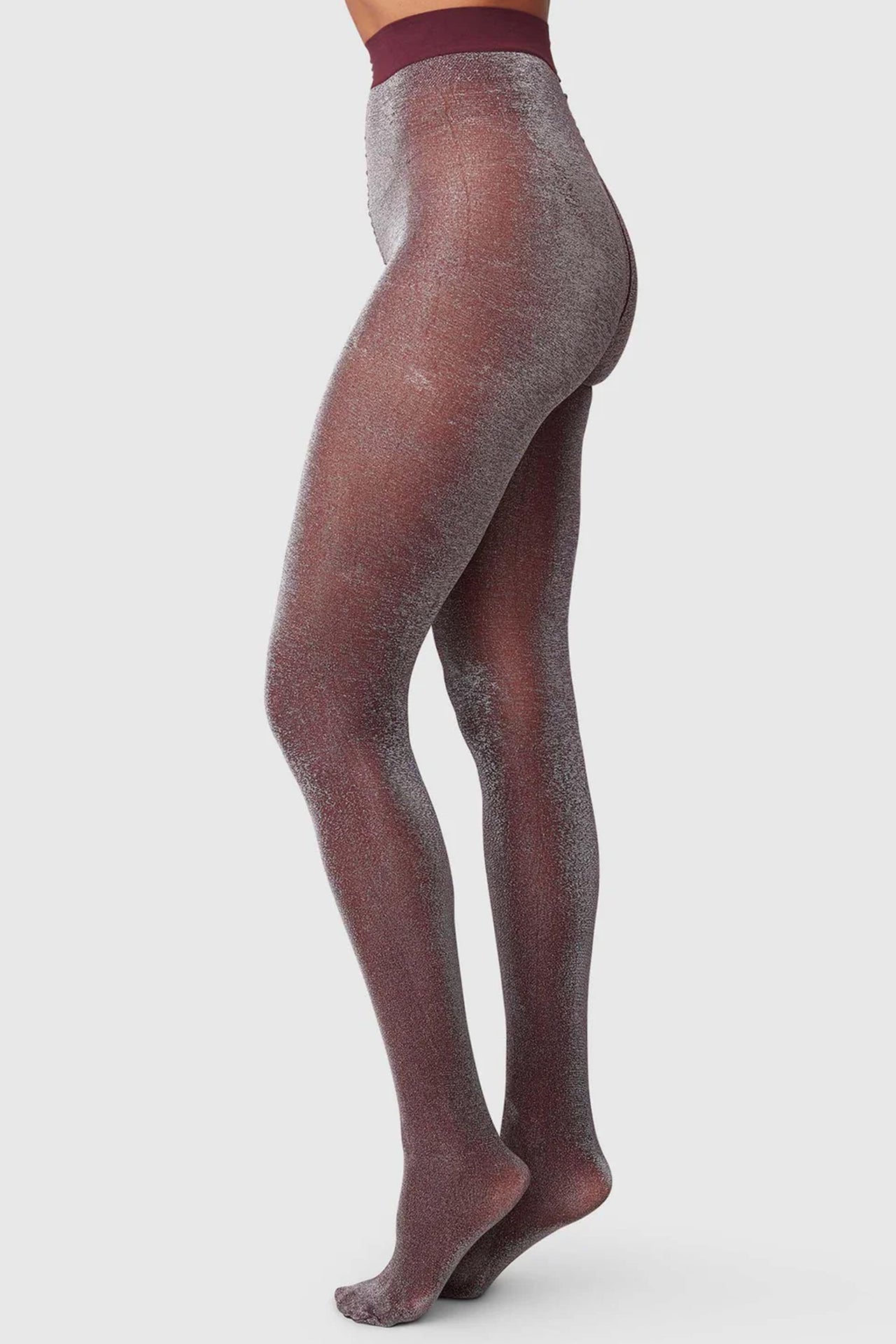 Swedish Stockings Tora shimmery tights in plum & silver. Side view on model.