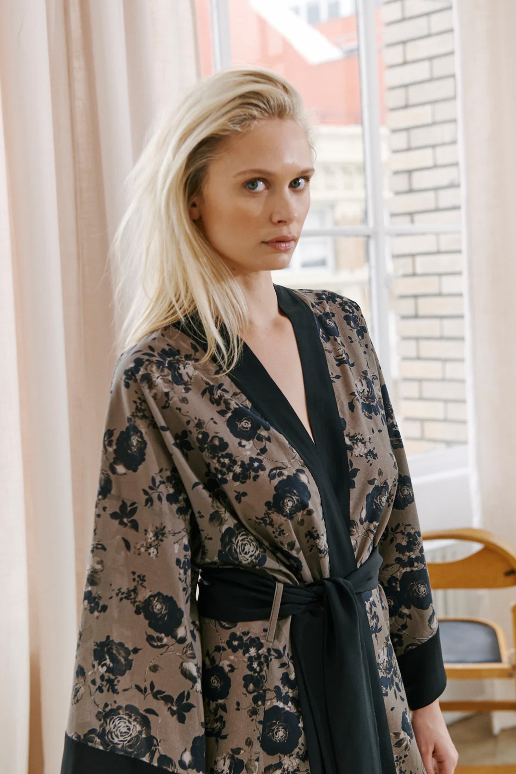 Else Euphoria taupe robe with black floral print and black silk trim. Image shows the robe on model, front view, featuring the wide kimono style sleeves and silk waist tie.