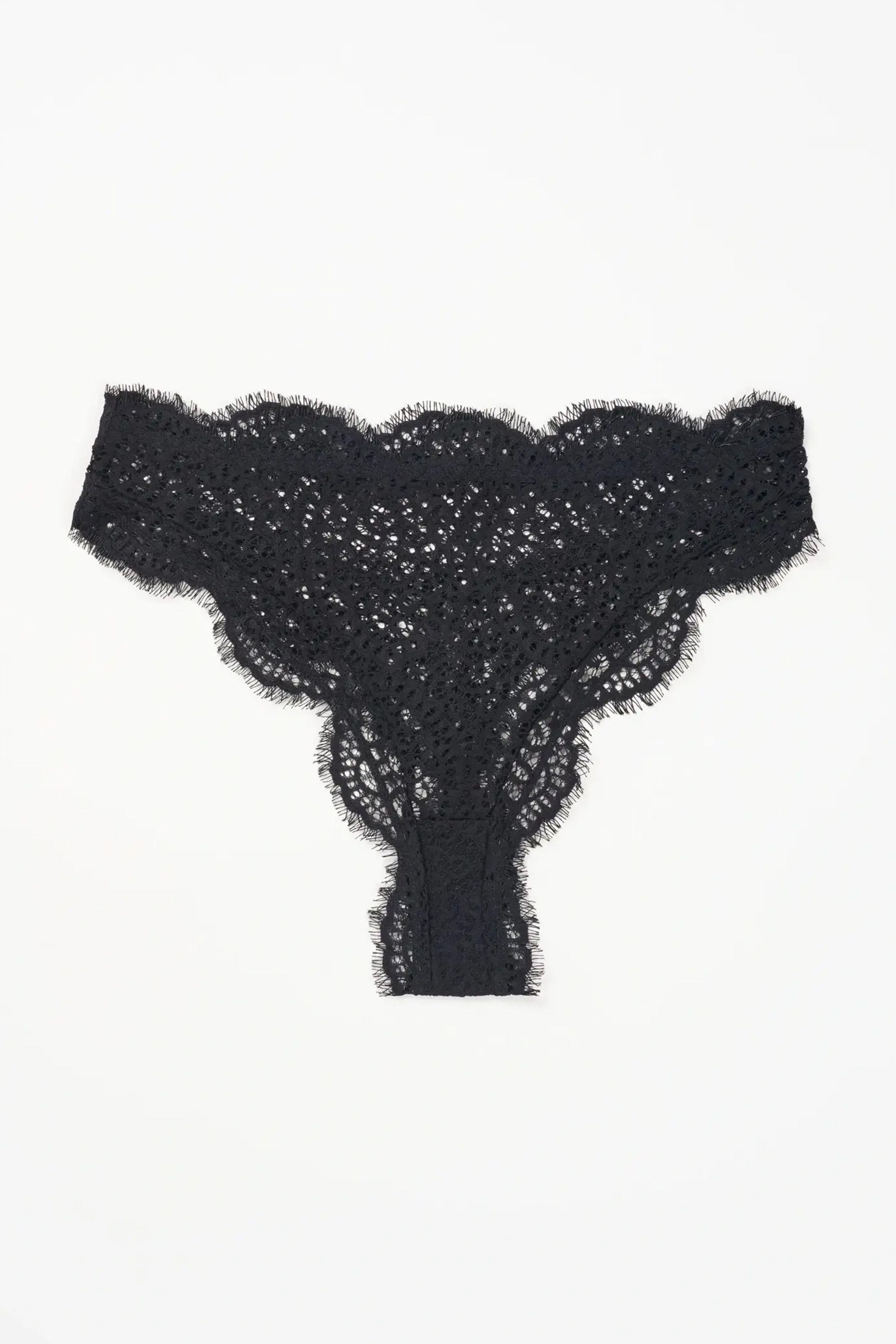 Else Monique black lace thong shown flat on plain white background. Geometric lace pattern with scalloped edges and eyelash detailing.