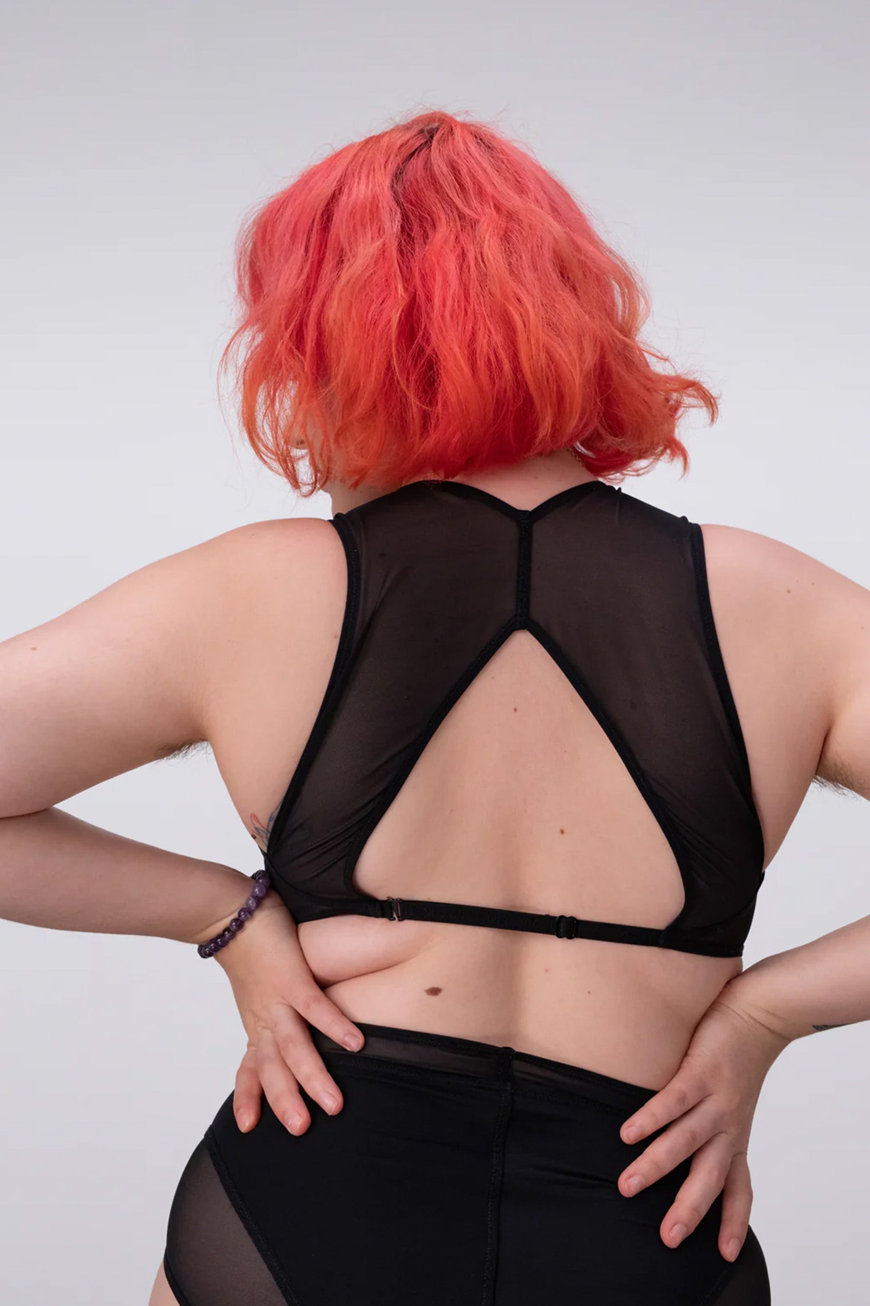 La Fille d'O Futura high neck bra, back view on model showing adjustable band strap, swan hook closure, triangular cutout at mid back, and racerback style top