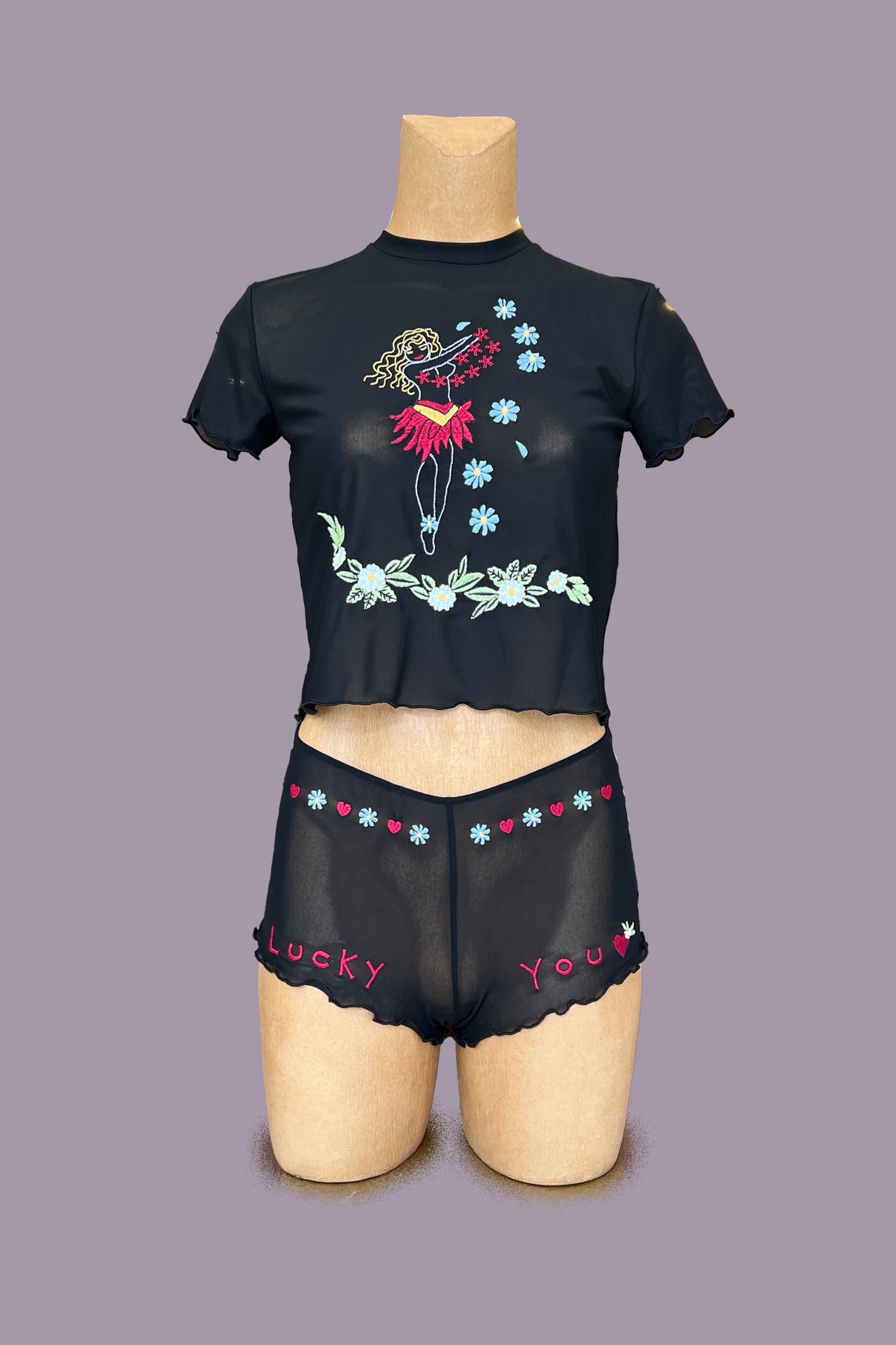 Only Hearts Aloha Honolulu Flower Girl Baby Tee in black mesh. Shown on mannequin, front view,showing lettuce edge on sleeves and hem, and floral and hula girl embroidery 