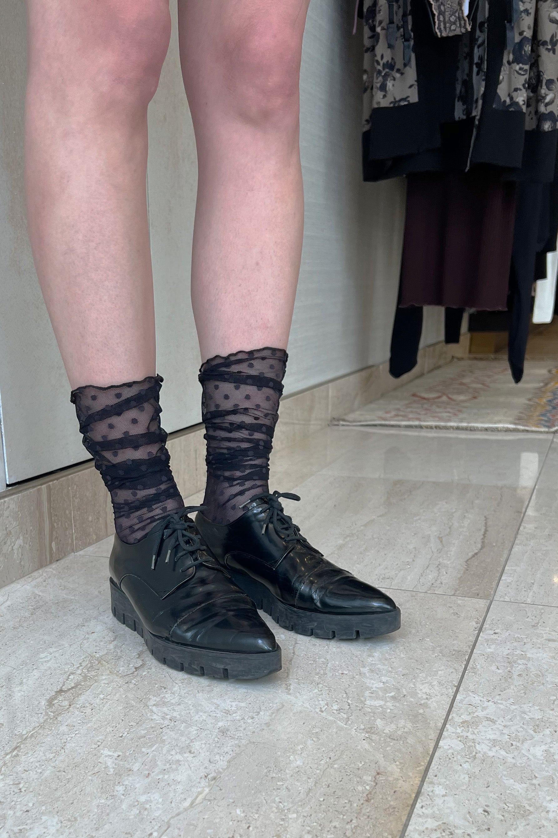 Only Hearts Coucou Lola polka dot mesh ankle sock in black. Front/side view on model showing socks scrunched down around the ankle. 