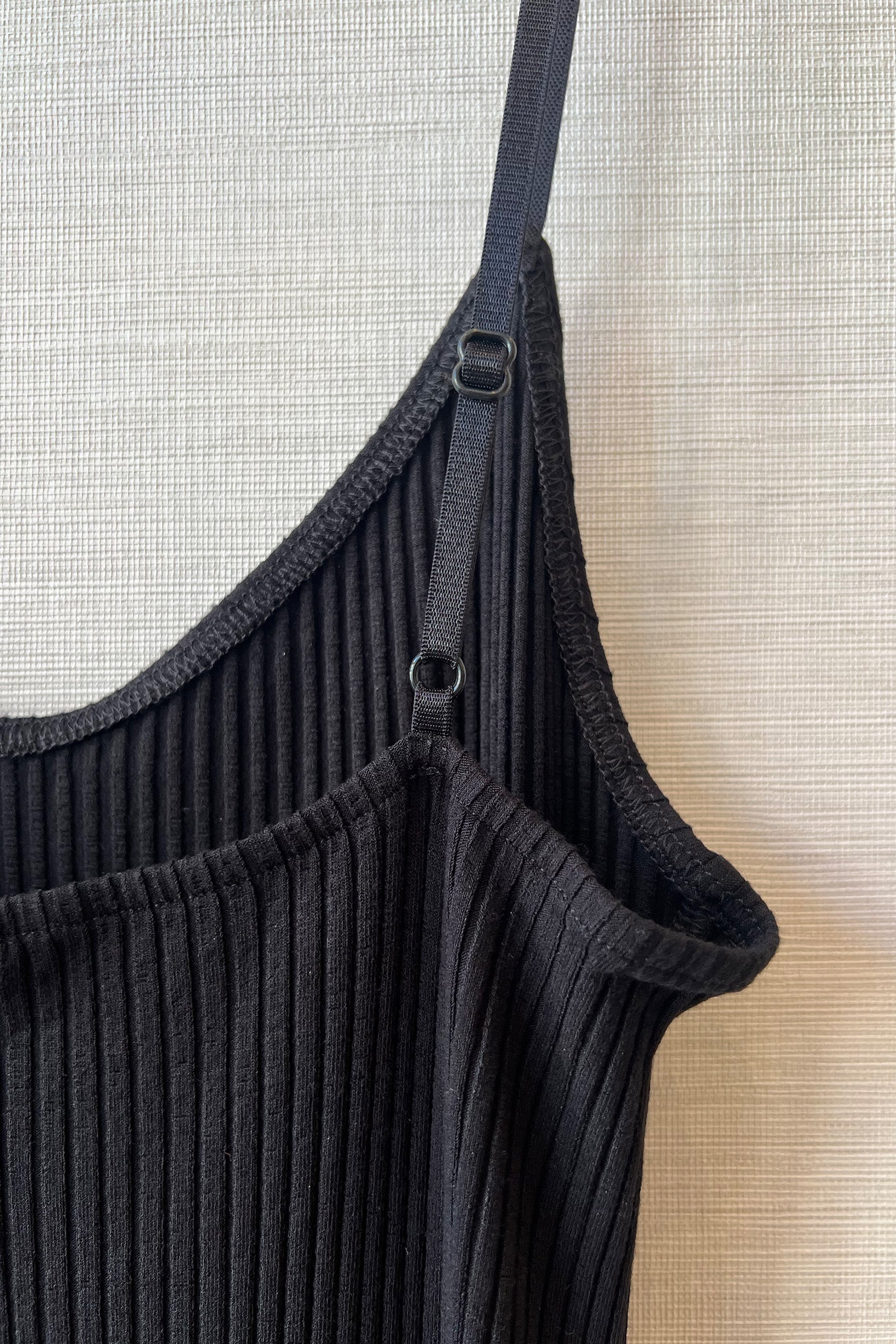 Close up of Only Hearts Eco Rib slip dress in black, showing interior surged stitching, adjustable elastic shoulder strap, and ribbed knit.