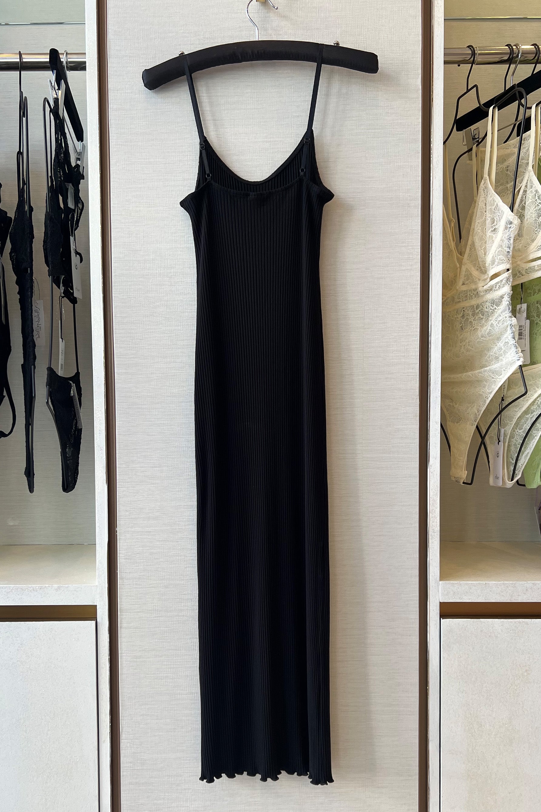 Only Hearts Eco Rib slip dress in black, back view on hanger. Image shows the ribbed knit, lettuce edge hemline, and adjustable spaghetti straps. 