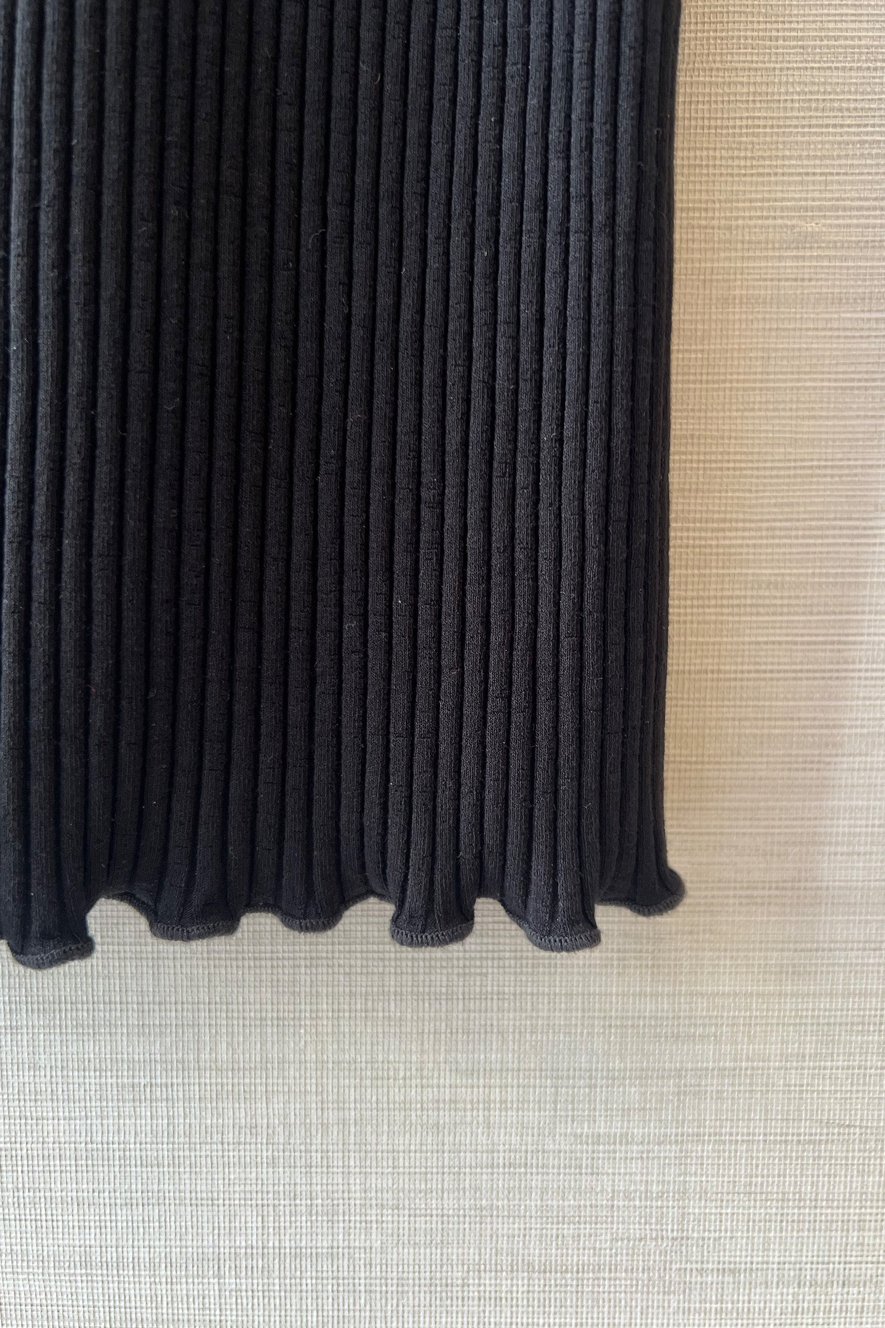 Close up of Only Hearts Eco Rib slip dress in black, showing lettuce edge hem and ribbed knit.