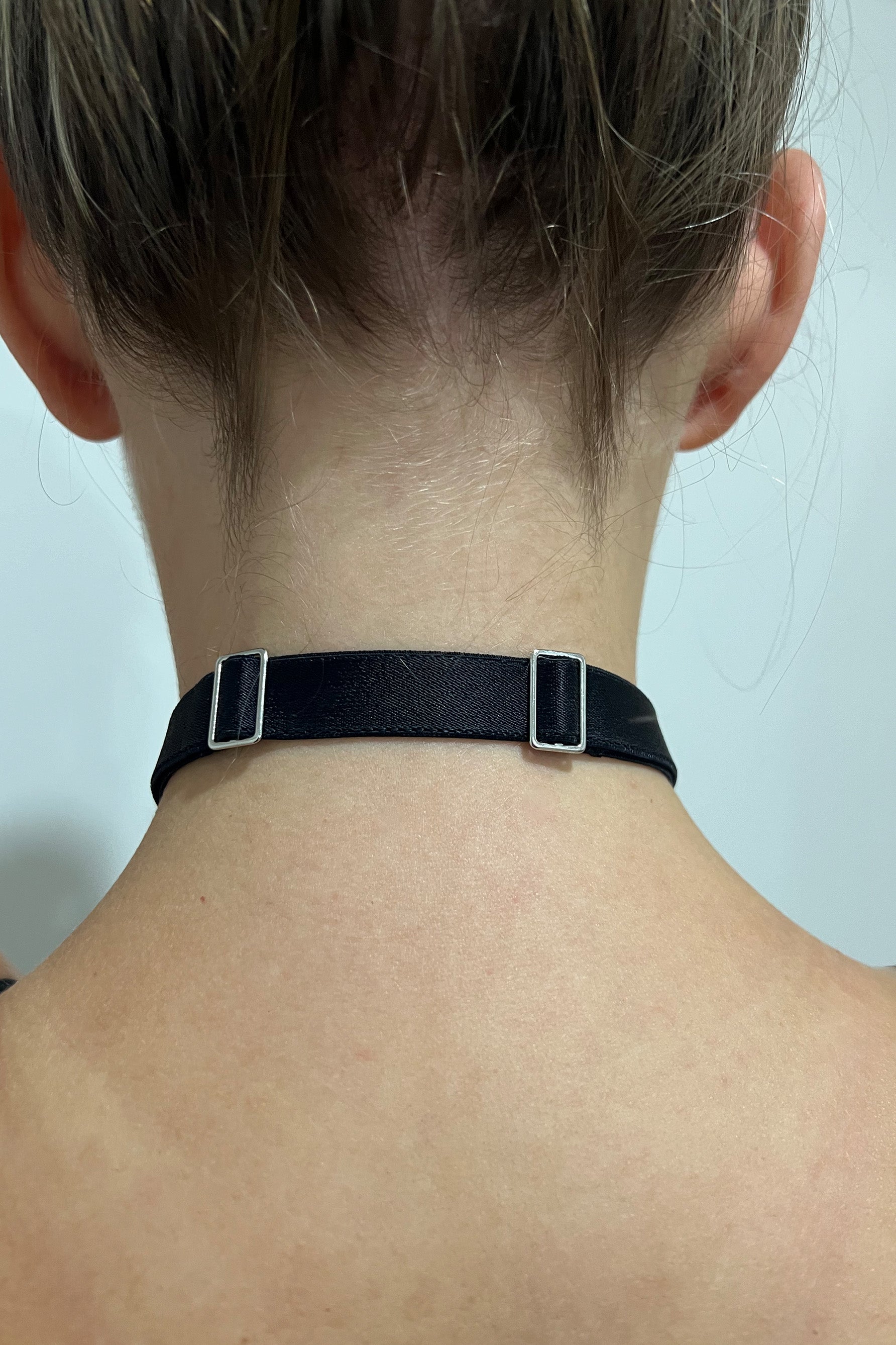 Paloma Casile La Nuit Lara choker, shown on model, back view. Image shows black elastic and silver toned sliders to adjust the length of the choker. 