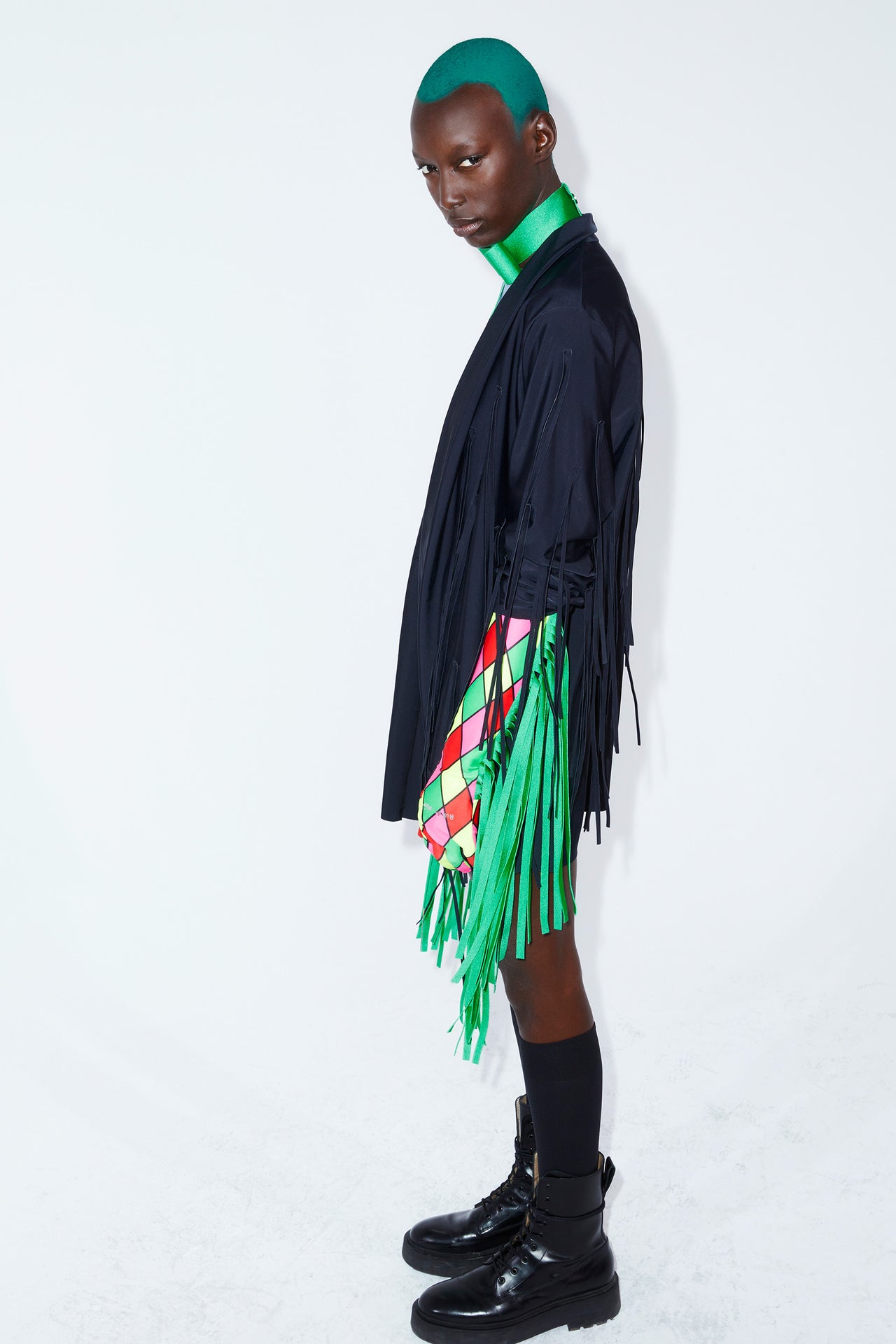 Ruban Noir fringe gloves in red, pink, green and yellow diamond print outlined in black. Green long fringe. Shown on model in black fringe jacket and green bowtie choker. 