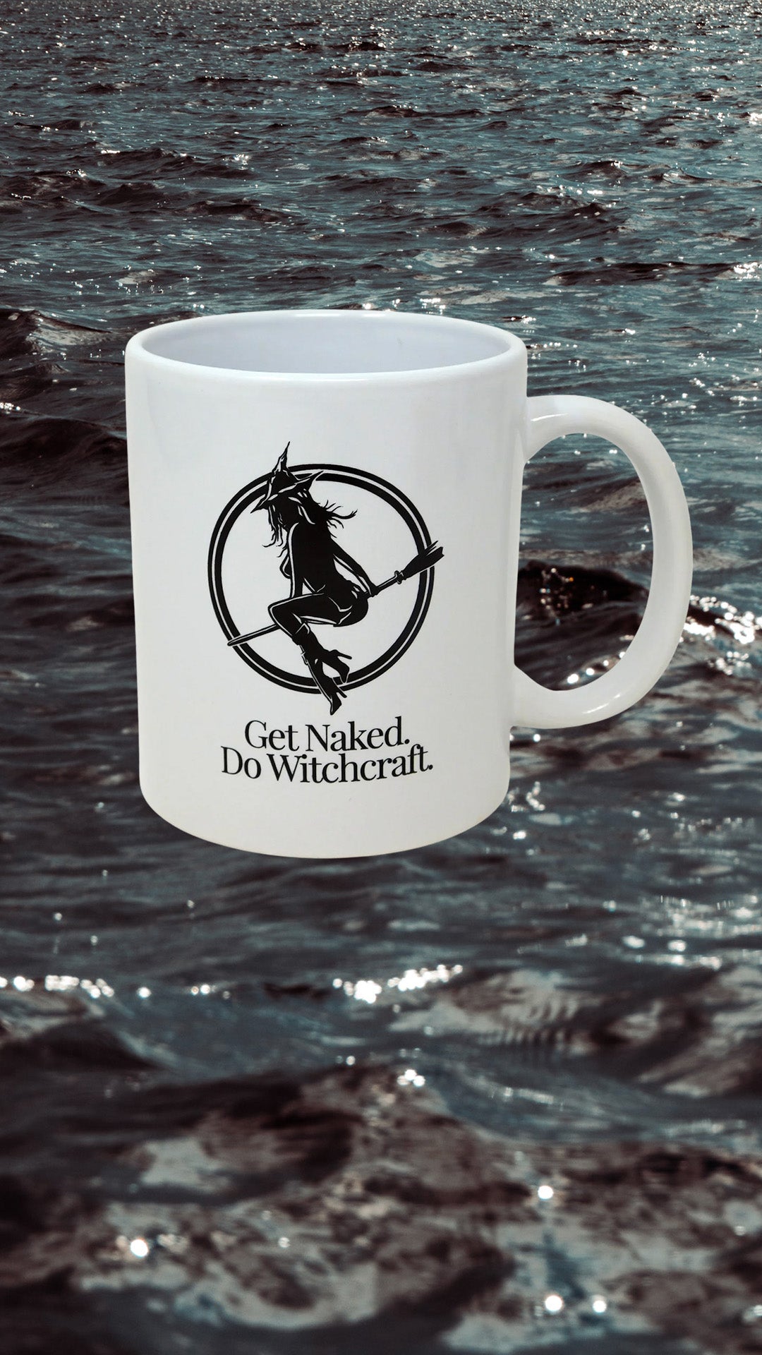 White ceramic mug with witch on broomstick in an open circle, with the phrase "get naked. do witchcraft" in serif font below.