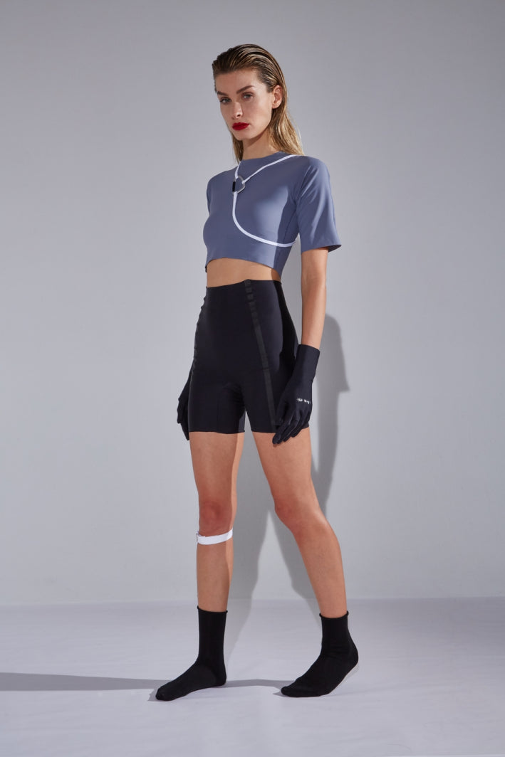 Ruban Noir Dorian gray-blue elbow length sleeve crop top, front view on model styled with mid rise jeans. The top's simple silhouette features a high neck and seamless sleeve/waist hemline.