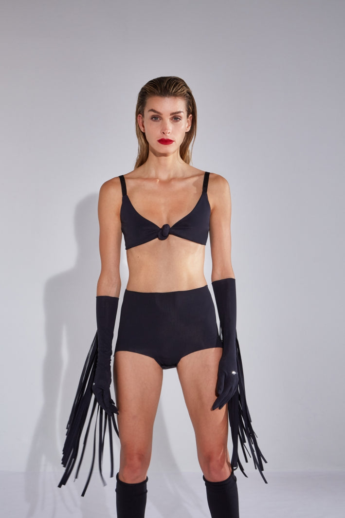 Ruban Noir black elbow gloves with long fringe. Shown on model in black knot front bralette, and black shorts/briefs.